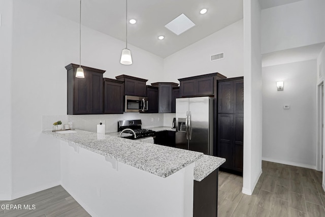 kitchen featuring visible vents, dark brown cabinets, high vaulted ceiling, a peninsula, and stainless steel appliances