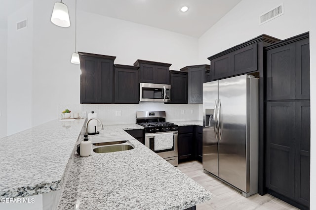 kitchen featuring visible vents, a peninsula, stainless steel appliances, and a sink