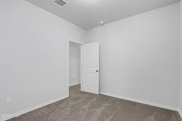 carpeted spare room with visible vents and baseboards