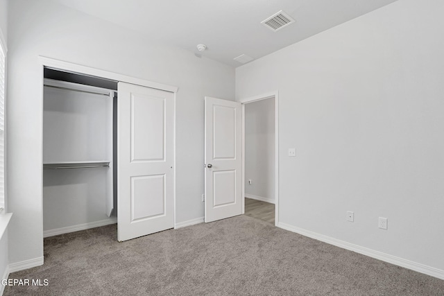 unfurnished bedroom featuring a closet, visible vents, carpet flooring, and baseboards