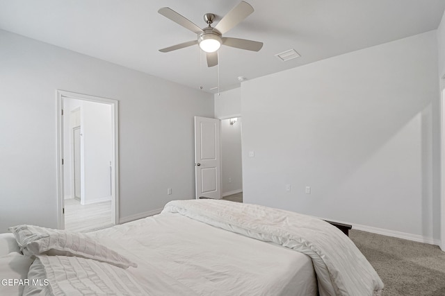 carpeted bedroom with visible vents, baseboards, and ceiling fan