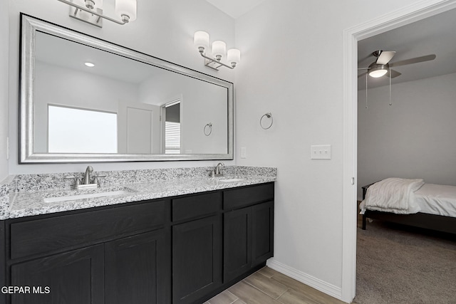 full bath with double vanity, wood finish floors, a ceiling fan, and a sink