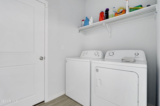 washroom featuring laundry area, light wood-style flooring, baseboards, and washer and clothes dryer