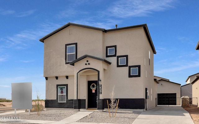 mediterranean / spanish house with stucco siding, driveway, fence, and an attached garage