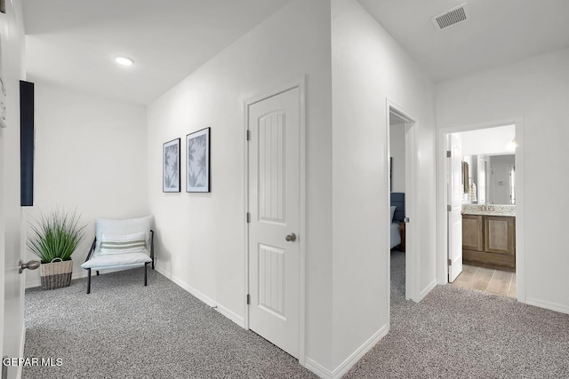 hallway featuring carpet flooring and baseboards