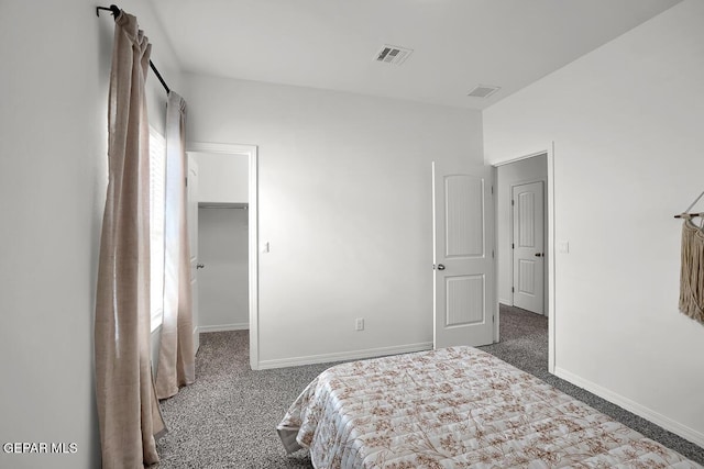 carpeted bedroom featuring a spacious closet and baseboards