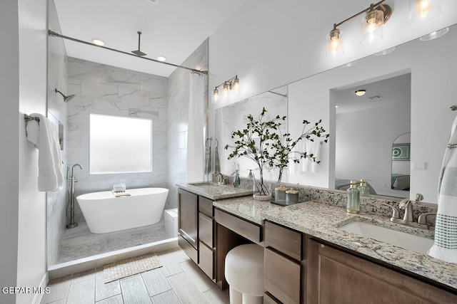 full bath with a freestanding tub, double vanity, a shower with shower curtain, and recessed lighting