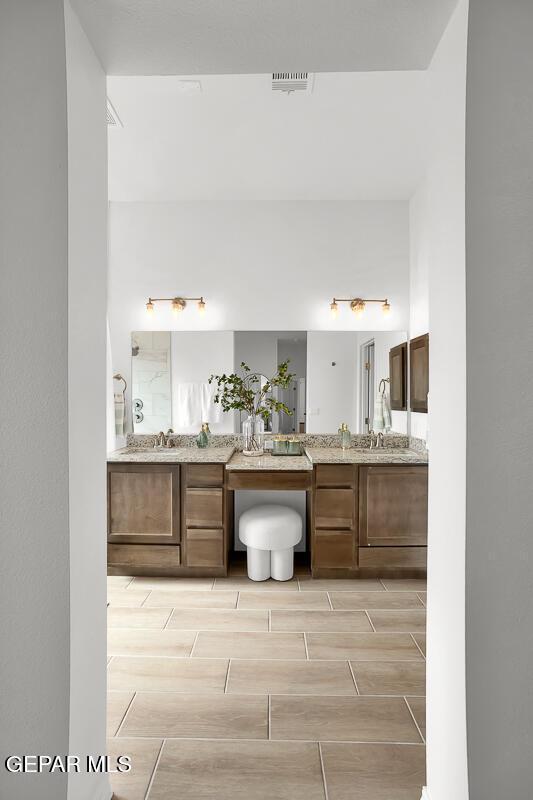 bathroom featuring two vanities and wood finish floors
