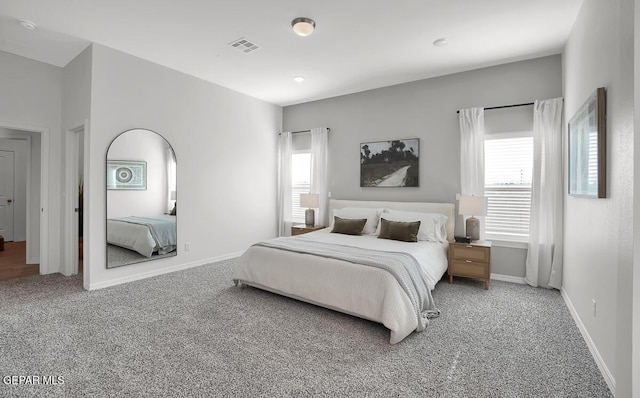 bedroom featuring carpet, multiple windows, and baseboards