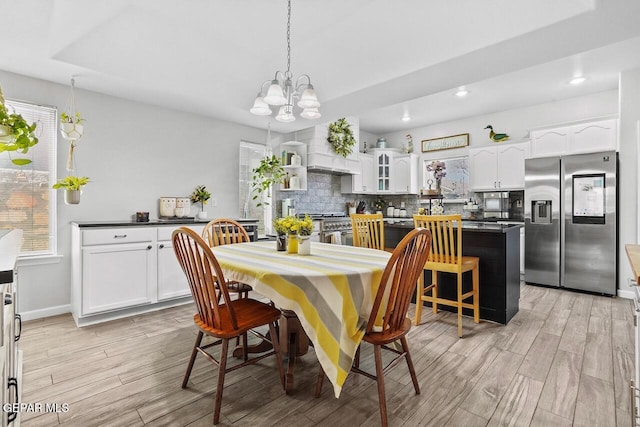 dining room featuring plenty of natural light, light wood finished floors, and a chandelier