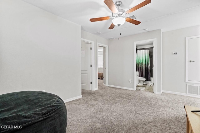 carpeted bedroom with baseboards, visible vents, ensuite bathroom, and ceiling fan