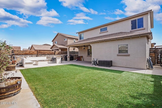 rear view of house featuring a yard, a patio, stucco siding, and fence