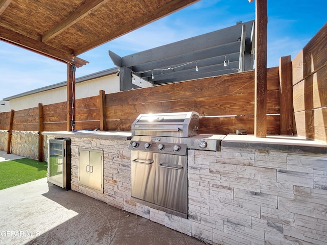 view of patio / terrace featuring grilling area, an outdoor kitchen, and fence