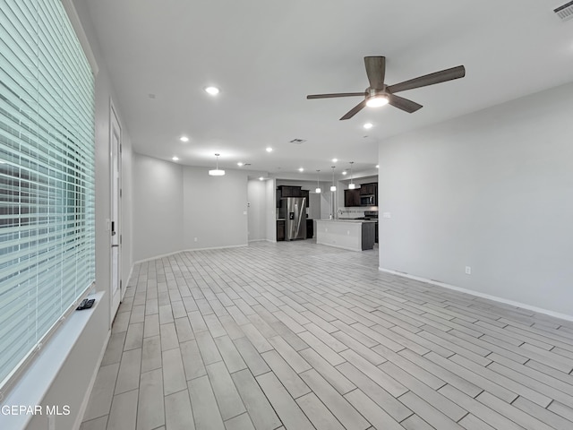 unfurnished living room featuring visible vents, light wood-style flooring, a ceiling fan, recessed lighting, and baseboards