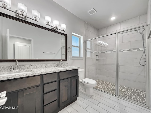 bathroom with a sink, toilet, and a shower stall