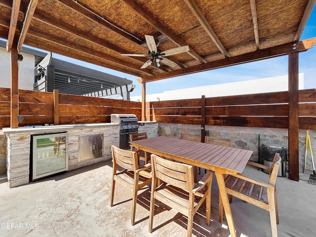 view of patio / terrace featuring area for grilling, a ceiling fan, a fenced backyard, outdoor dining area, and an outdoor kitchen