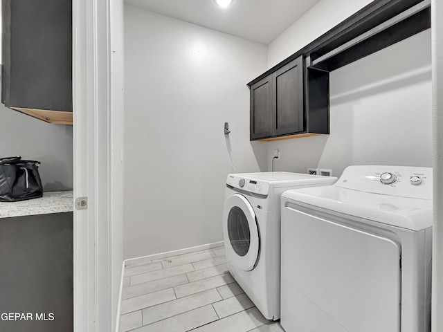 laundry room featuring cabinet space, baseboards, and washer and clothes dryer