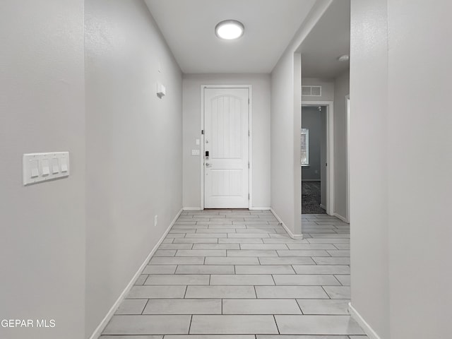 hall featuring visible vents and baseboards