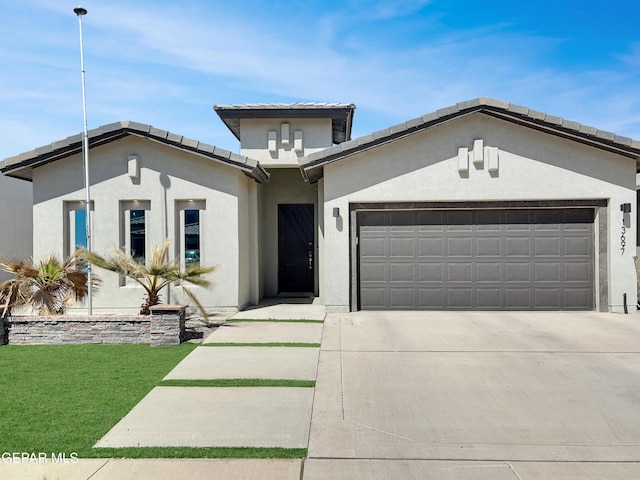 view of front of house featuring stucco siding, concrete driveway, and a garage