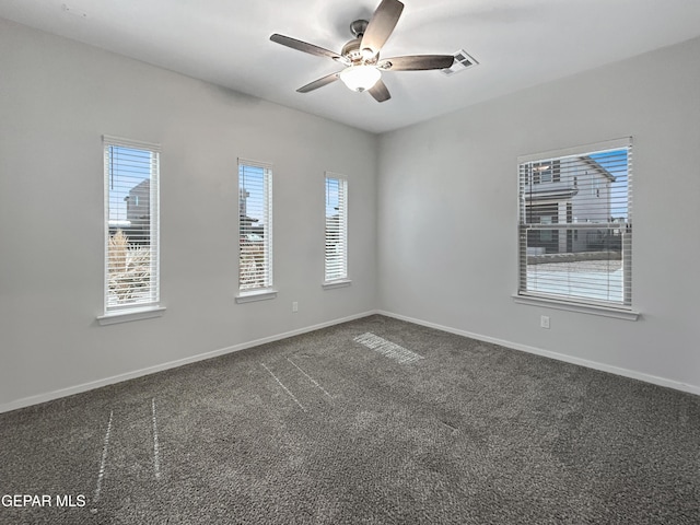 empty room with visible vents, baseboards, dark colored carpet, and ceiling fan