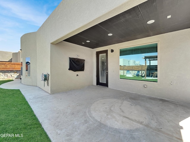 doorway to property featuring a patio and stucco siding