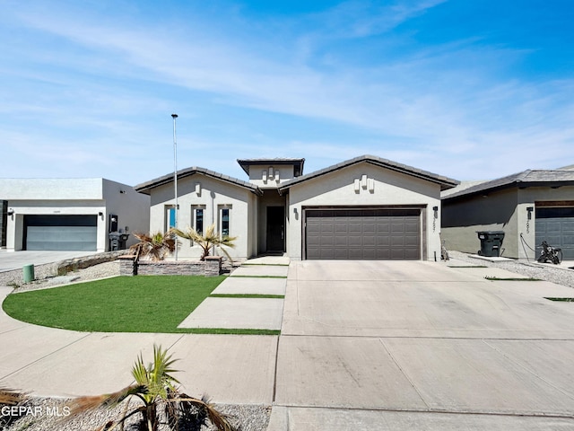 view of front of home with concrete driveway, an attached garage, a front lawn, and stucco siding