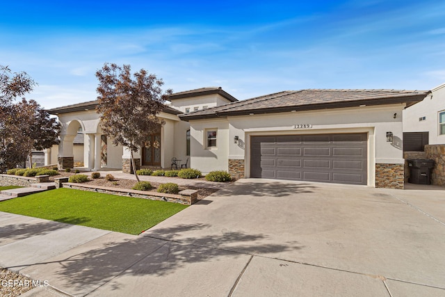 prairie-style house featuring driveway, stone siding, a garage, and stucco siding