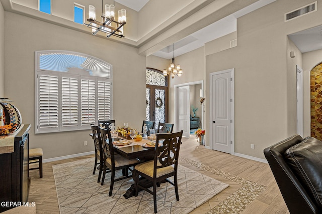 dining area with visible vents, a notable chandelier, and wood finished floors