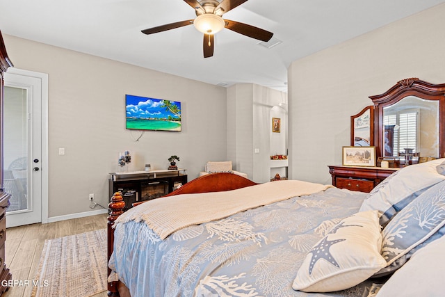 bedroom with ceiling fan, wood finished floors, visible vents, and baseboards