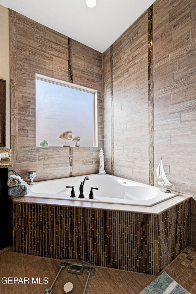 bathroom with a bath and tile walls