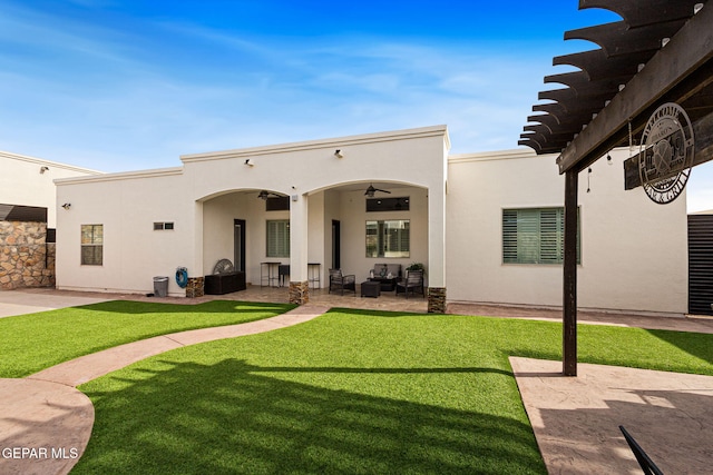 rear view of property with ceiling fan, a patio, a lawn, and stucco siding