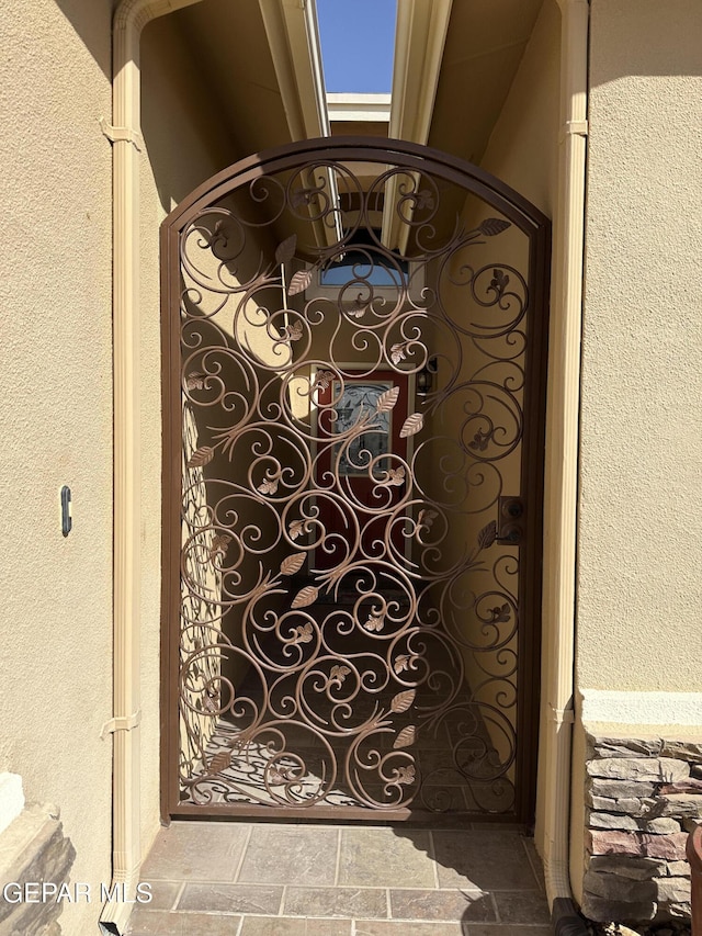 details featuring a gate and a textured wall