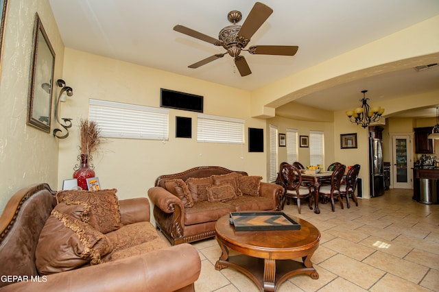 living area featuring ceiling fan with notable chandelier, light tile patterned floors, and visible vents