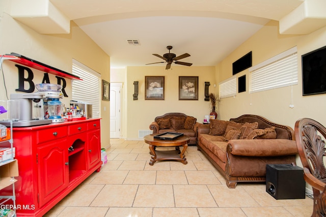 living room with light tile patterned floors, baseboards, visible vents, and a ceiling fan