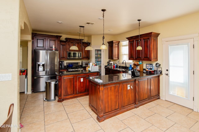 kitchen featuring stainless steel appliances, visible vents, light tile patterned flooring, a sink, and a peninsula