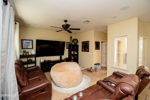 living area featuring light tile patterned flooring, visible vents, and a ceiling fan