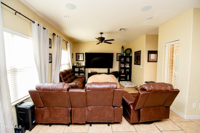 living room with ceiling fan, light tile patterned floors, visible vents, and baseboards