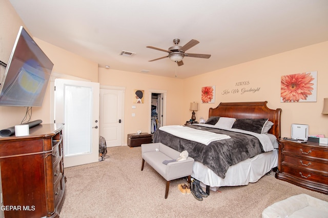 bedroom with a closet, visible vents, a spacious closet, a ceiling fan, and light carpet