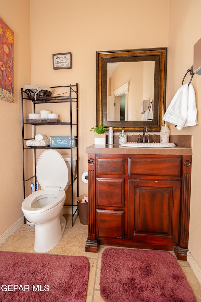 bathroom featuring vanity, toilet, and baseboards