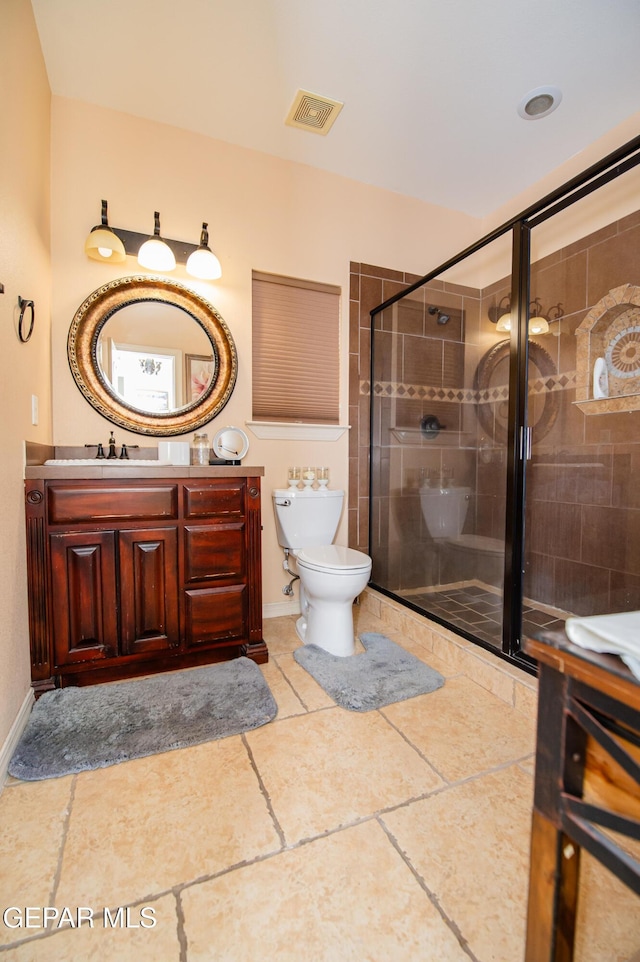 full bathroom with toilet, vanity, visible vents, baseboards, and a shower stall