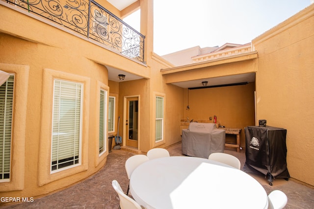 view of patio with outdoor dining space and a balcony