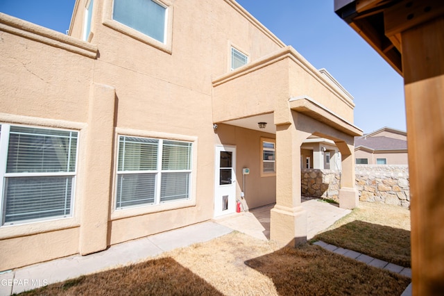 back of property with stucco siding, fence, and a patio