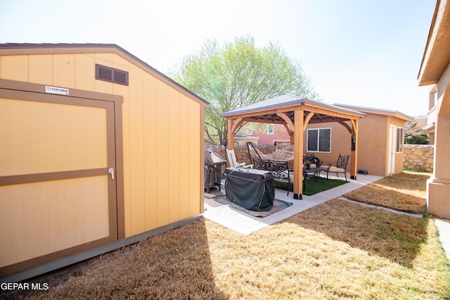 view of yard featuring a patio area, fence, an outdoor structure, and a gazebo