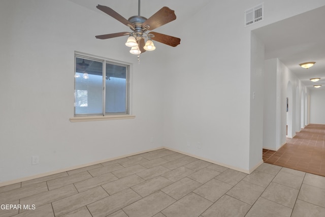 empty room with light tile patterned floors, visible vents, baseboards, and a ceiling fan