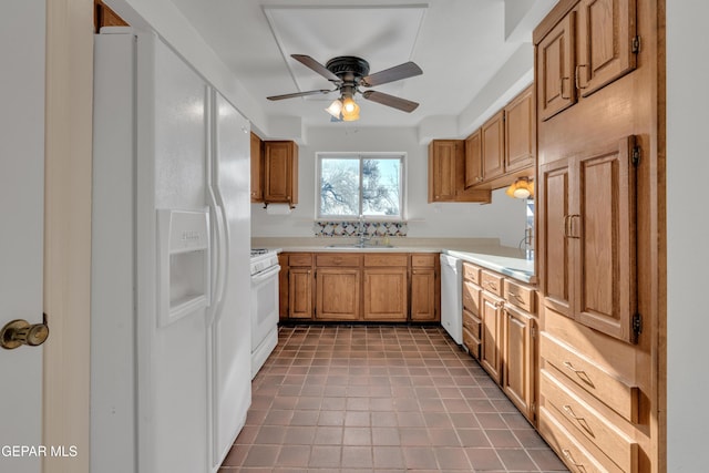 kitchen featuring brown cabinetry, white appliances, light countertops, and a sink