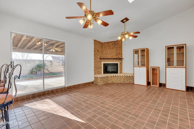 unfurnished living room featuring a ceiling fan, baseboards, lofted ceiling, a fireplace, and tile patterned floors