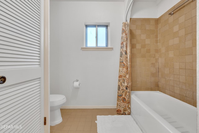 bathroom featuring baseboards, toilet, and shower / bath combo with shower curtain