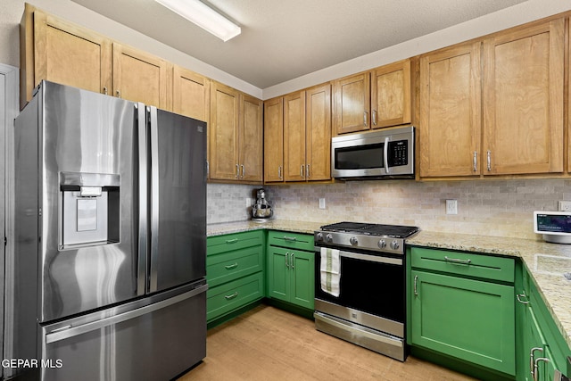 kitchen featuring light stone counters, backsplash, appliances with stainless steel finishes, and light wood-style flooring