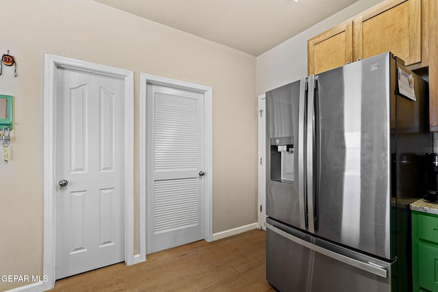 kitchen featuring stainless steel fridge, baseboards, and light wood-style floors