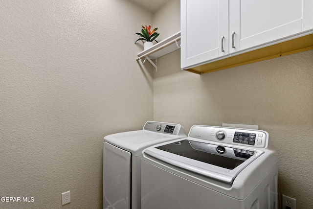 laundry room with cabinet space, washing machine and dryer, and a textured wall